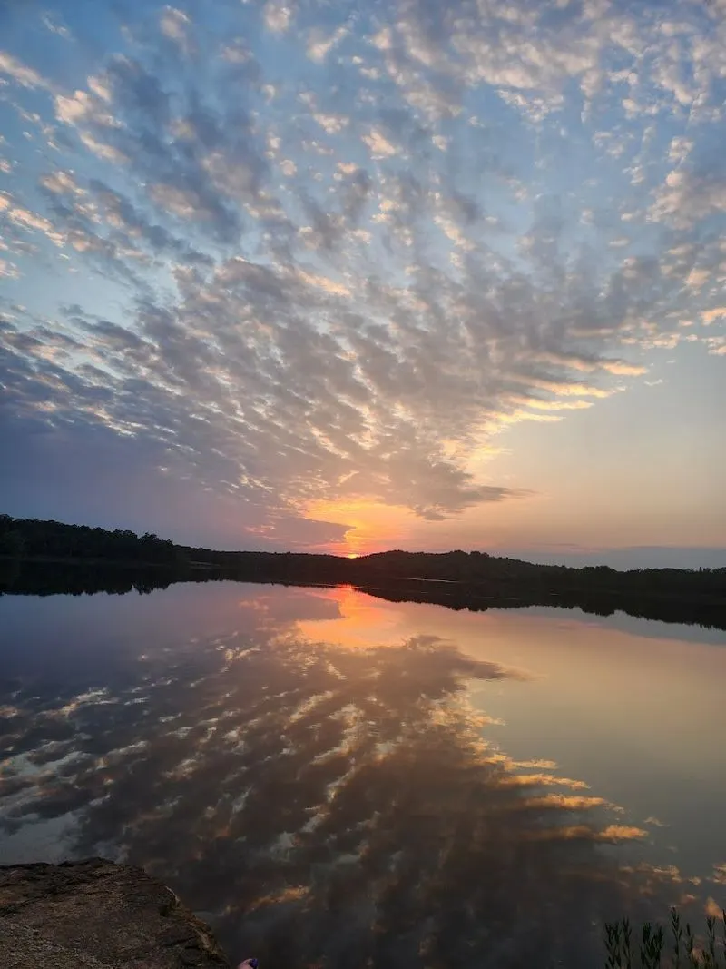 Still lake water reflecting a sunset